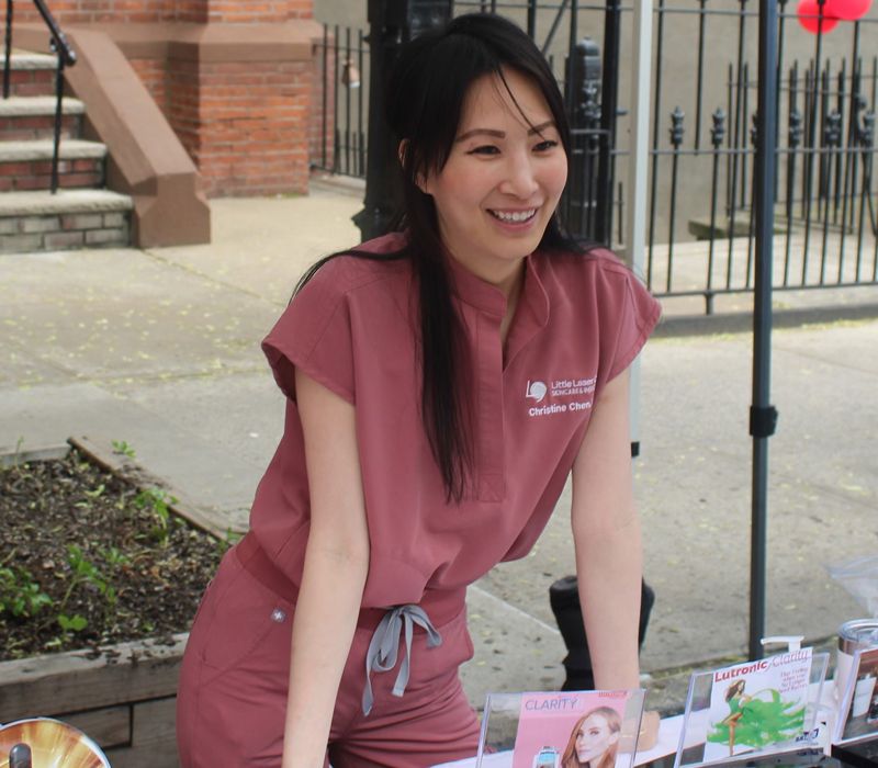 long island city med spa founder Christine Chen smiling outside wearing scrubs