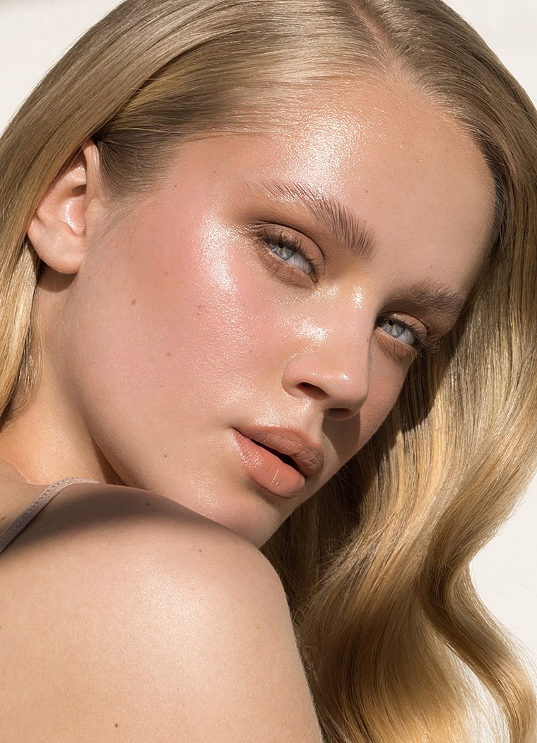 Close-up of a woman with glowing skin.