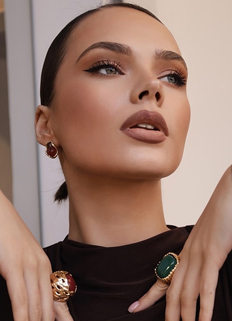 Model showcasing jewelry and makeup elegance.