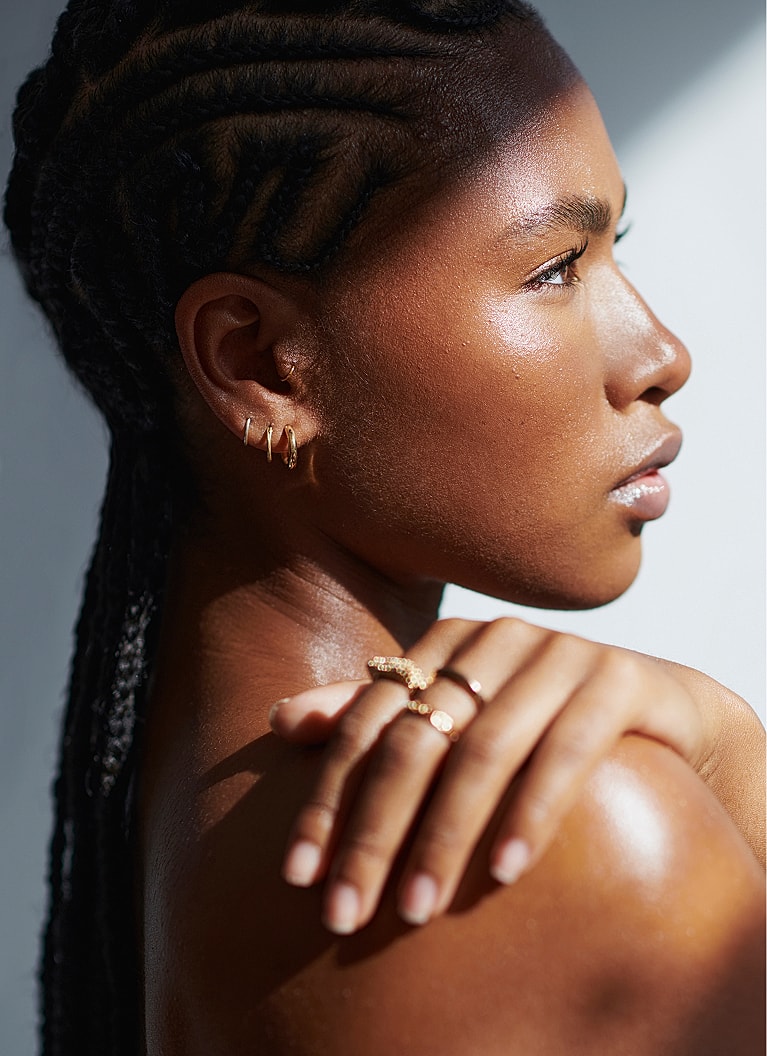 Profile of a woman showcasing gold jewelry.
