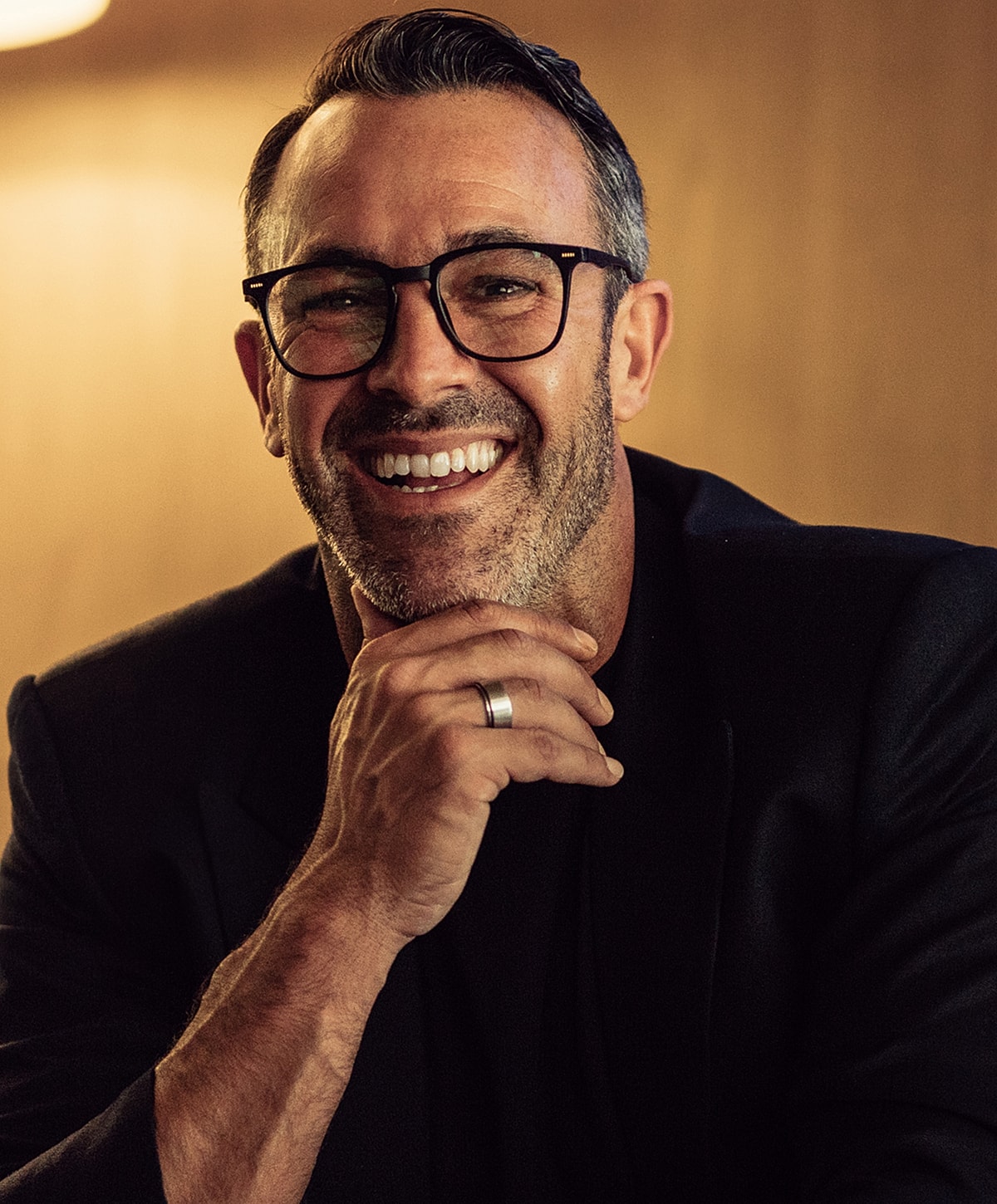 Smiling man in glasses with stylish outfit.