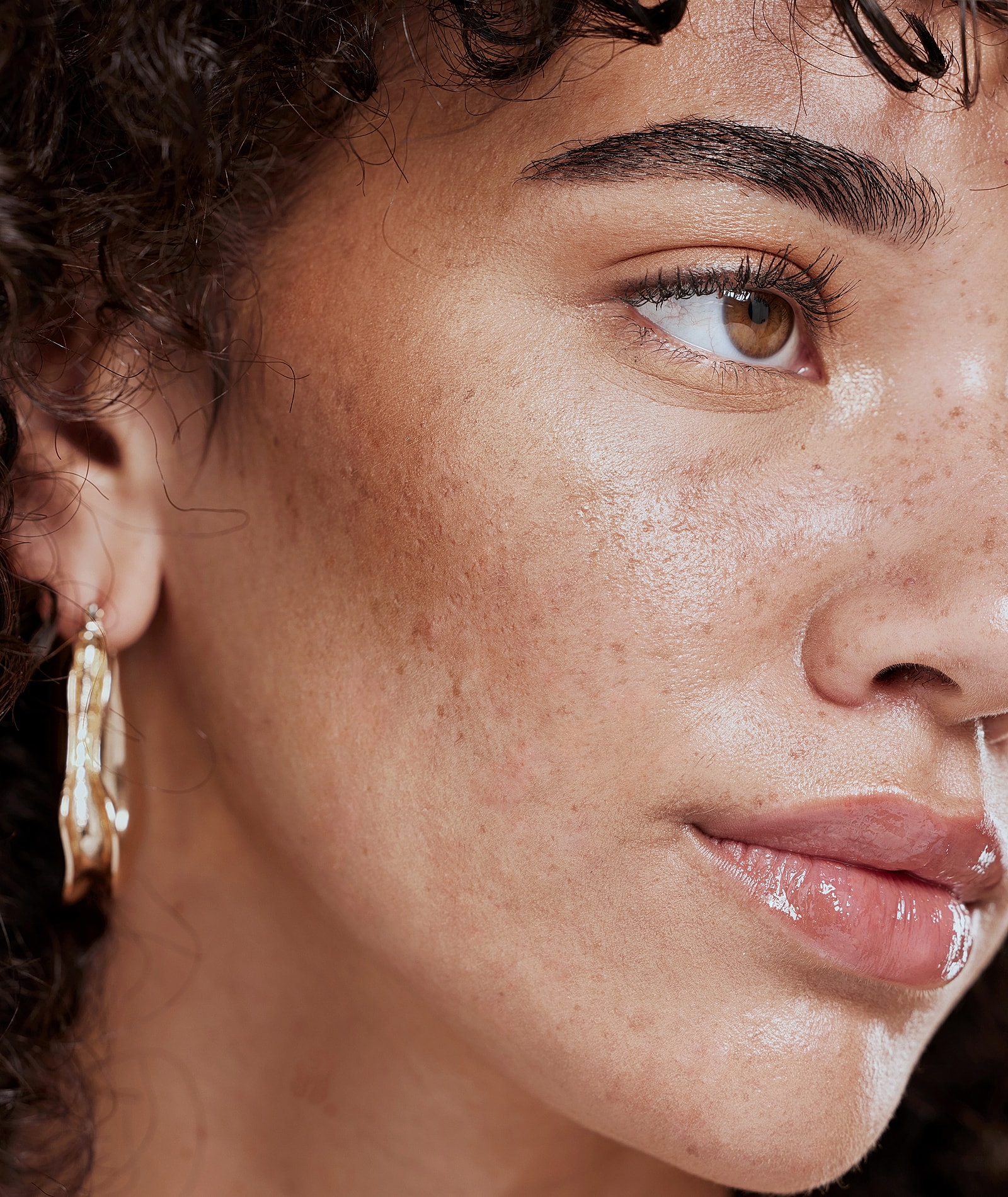 Woman with expressive gaze against dark background.