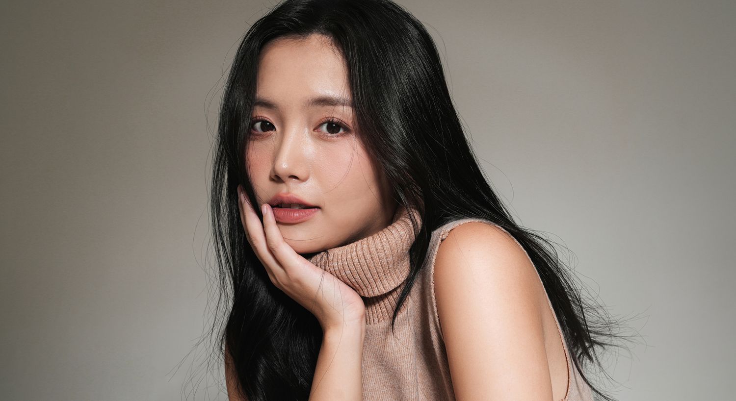 Woman with long hair in a turtleneck sweater.