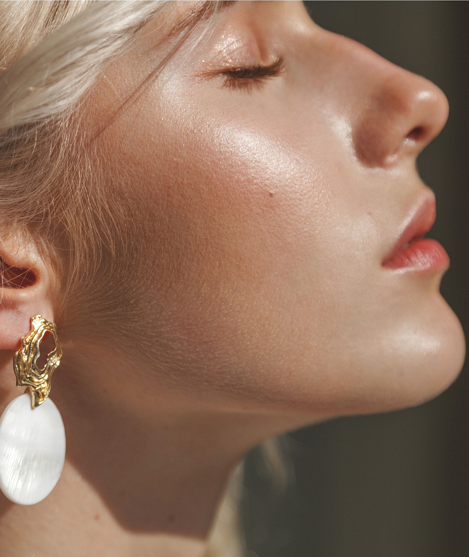 Female profile with elegant jewelry and radiant skin.